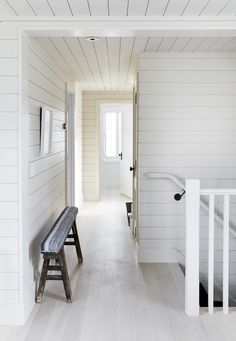 an empty hallway with white walls and wood flooring