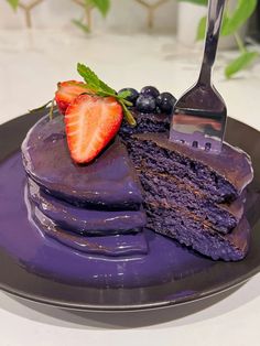 a piece of cake on a plate with a fork next to it and some berries