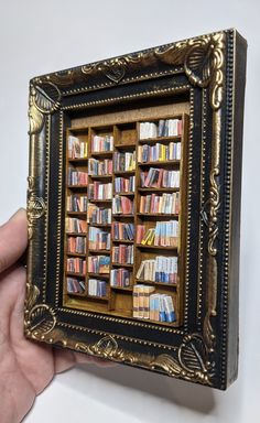 a person holding up a book case with many books in it