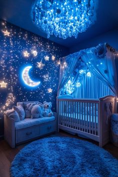 a baby's room decorated in blue with stars and moon lights on the ceiling