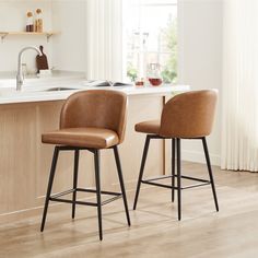 two brown leather stools in front of a kitchen counter