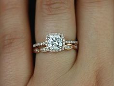 a woman's hand with a diamond ring on top of her finger and the engagement band