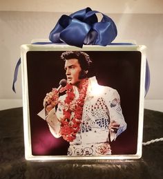 an elvis presley photo with a blue bow around it's neck on a table