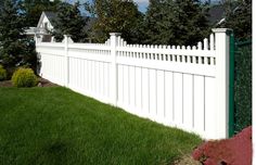 a white picket fence in front of some trees