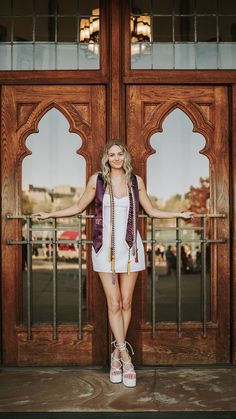 a woman standing in front of a door with her hands on the railing and looking at the camera