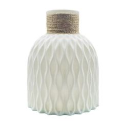 a white vase with wavy lines on the bottom and gold trimmings around it