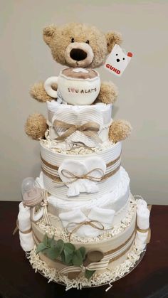 a teddy bear is sitting on top of a diaper cake