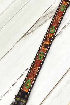 a brown and green tie on top of a white wooden floor next to a wall