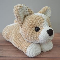 a small stuffed dog laying on top of a wooden table