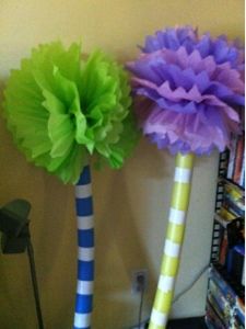 two vases with flowers in them sitting on a table next to a book shelf