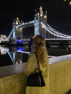 a woman is looking at the tower bridge