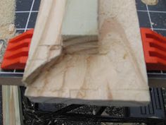 a piece of wood sitting on top of a table next to a red and white object