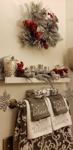 a christmas wreath is hanging on the wall above towels and other holiday decorations in front of a fireplace mantel