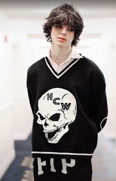 a person wearing a sweater with a skull on it