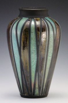 a black vase with green and brown stripes on it