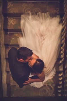 a man and woman are kissing on the stairs