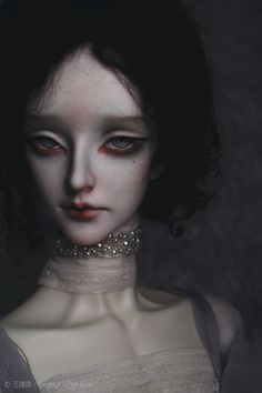 a creepy doll with blue eyes and white skin wearing a choker necklace, dark background