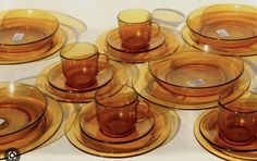 a table topped with lots of yellow glass plates and cups on top of each other