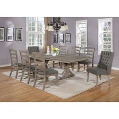 a dining room table with chairs and a chandelier hanging from the ceiling in front of purple walls