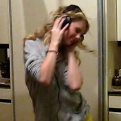 a woman is talking on her cell phone in the kitchen