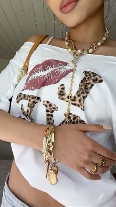 a close up of a person wearing a white shirt with leopard print on the sleeves