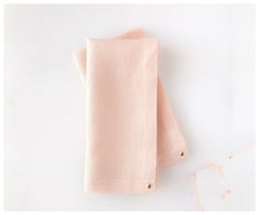 two folded pink napkins sitting on top of a white countertop next to each other