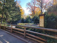 a wooden fence next to a forest filled with trees