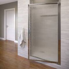 a bathroom with a large shower and wooden flooring next to a white door that has a towel hanging on it