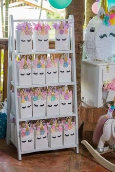 a white shelf filled with lots of small bags and unicorn decorations on top of it