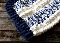 a blue and white crocheted dishcloth sitting on top of a wooden table