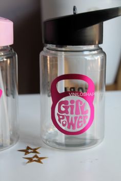 two glass jars with pink stickers on them