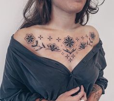 a woman with tattoos on her chest and shoulder