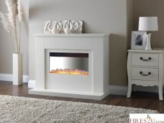 a white fireplace with an electric fire in it