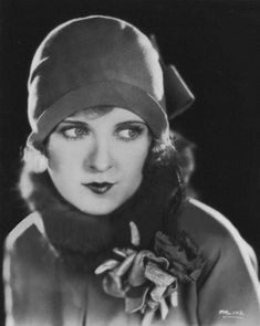 black and white photograph of a woman wearing a hat with a scarf around her neck