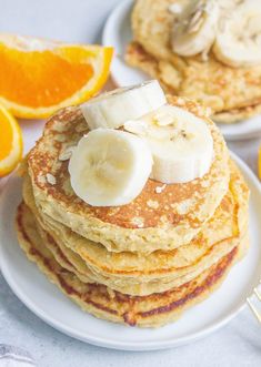 stack of pancakes with bananas and orange slices