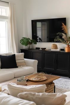 a living room filled with furniture and a flat screen tv mounted to the side of a wall