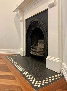 a fireplace with a black and white checkerboard design on the floor next to it