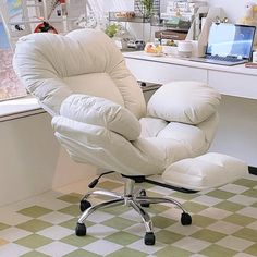 a white chair sitting in front of a desk with a laptop computer on top of it