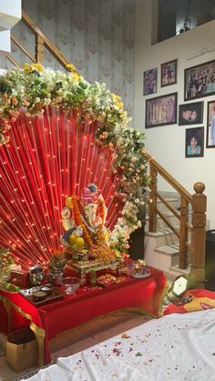 a red fan sitting on top of a table in front of a stair case filled with pictures