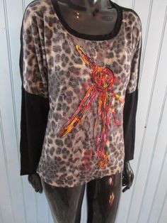 Retro T-shirt black/leopard print with a red design on the front. Size S. Made by Suzanna Paris from a cotton mix. Dimensions: Bust: 36 Inches. Length: 23 Inches. Sleeve: 15 Inches. Black Tiger Print Crew Neck Top, Black Crew Neck Top With Tiger Print, Casual Stretch Tiger Print Tops, Black Vintage Print Crew Neck Top, Black Crew Neck Top With Vintage Print, Leopard Print Graphic T-shirt For Summer, Black Graphic Tee With Vintage Print, Summer Leopard Print Graphic T-shirt, Black Tiger Print Long Sleeve Tops