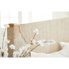 a bed with white linens and flowers in the foreground