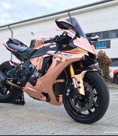 a pink motorcycle parked in front of a building