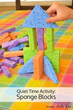 a child is playing with sponge blocks on the table and it looks like he's building