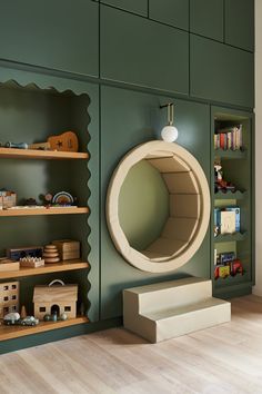 a room with green walls and shelves filled with toy items, including a circular mirror