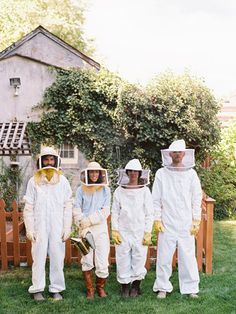 four people in bee suits standing next to each other