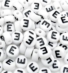 white beads with black letters and numbers on them