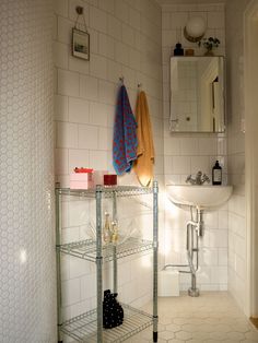 a bathroom with a sink, mirror and shelving unit