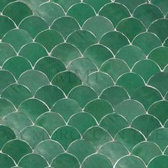 a close up view of a green fish scale tile