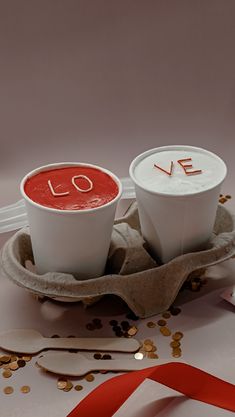 two coffee cups with love written on them