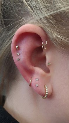 a close up of a person's ear with three different types of piercings